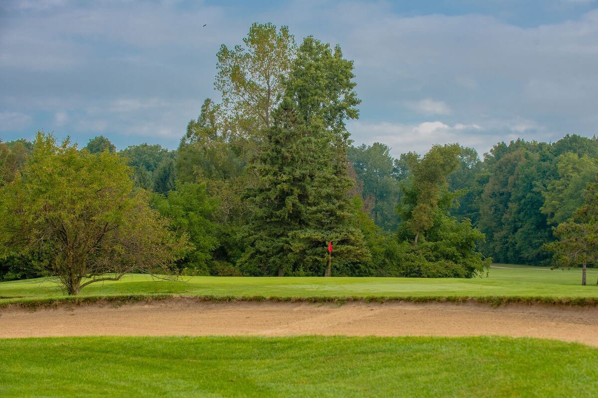 Sand bunker in the foreground with green and flag just beyond.