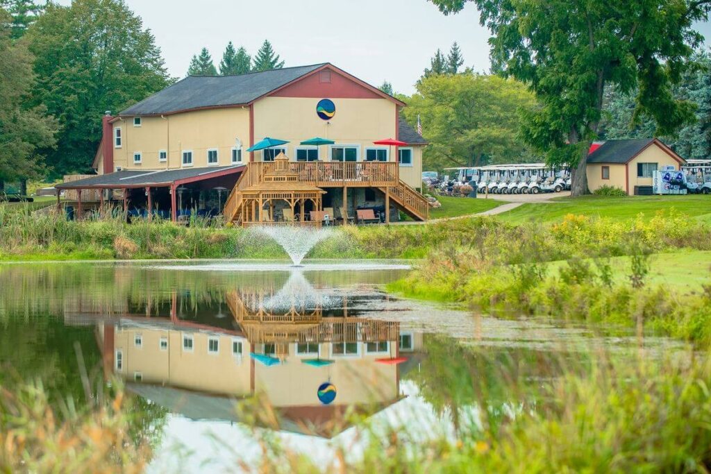 View of the clubhouse and outdoor seating from across the lake.